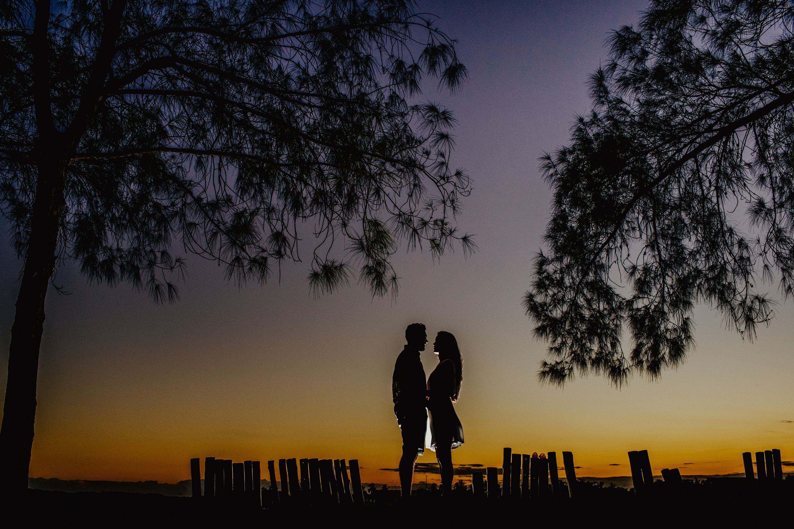 Silhouettes of romantic couple looking at each other during date in park